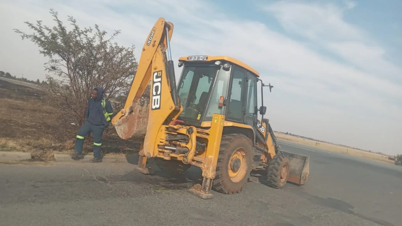 Backhoe at a roadside worksite by Seldariah Trading